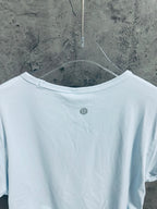 Light blue T-shirt back view with small round logo at upper back