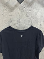 Dark navy T-shirt back view with small round emblem near upper back