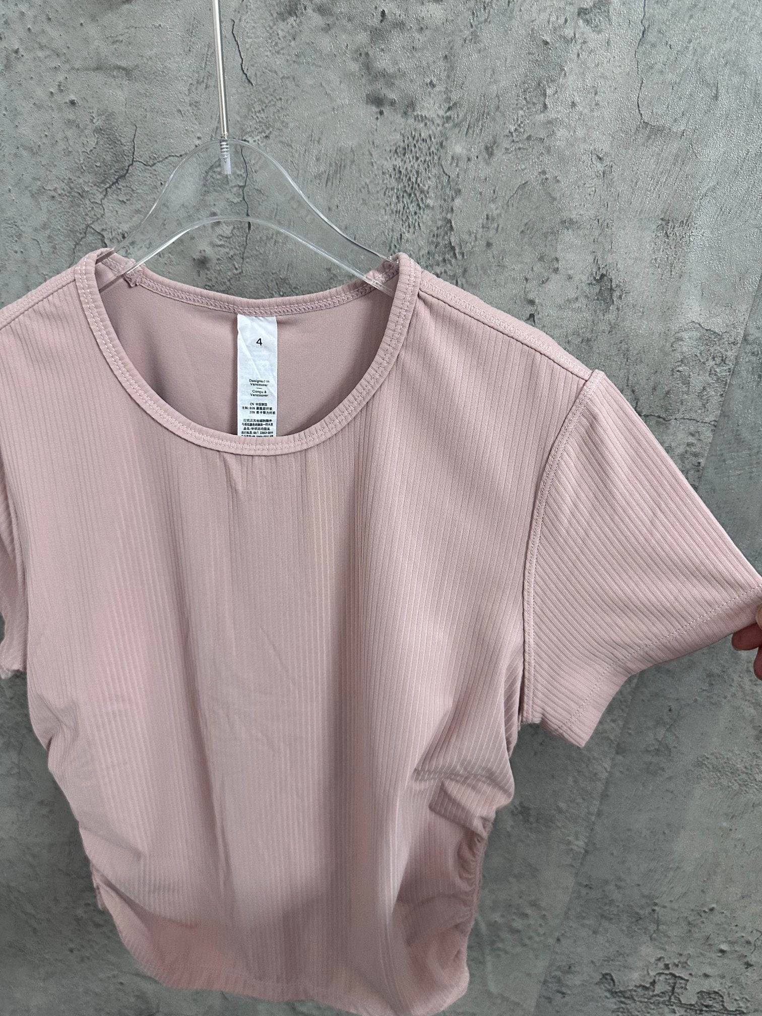 Light pink short-sleeve T-shirt with crew neck and subtle vertical ribbing.