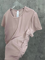 Light pink ribbed T-shirt on hanger with side twist