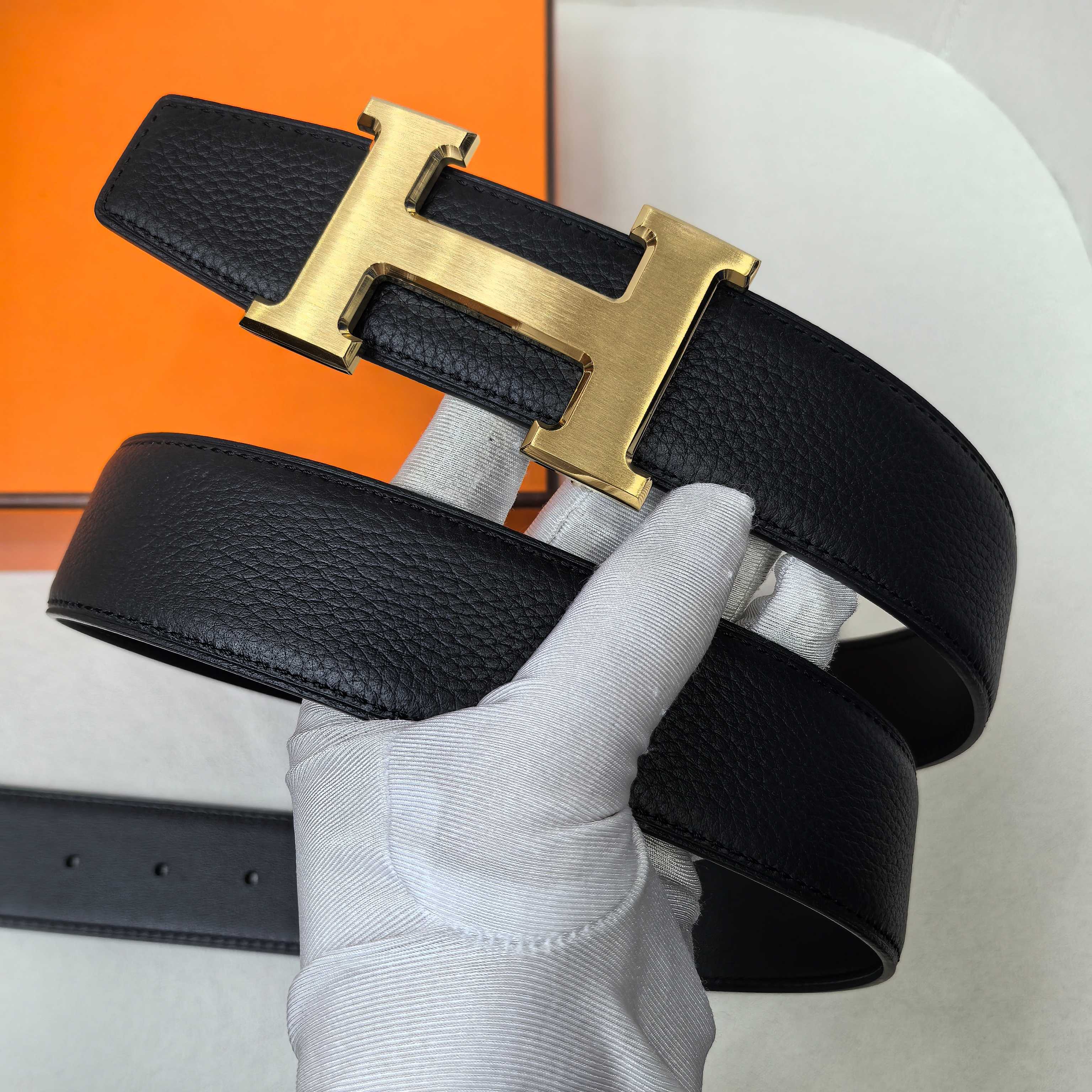 Hermes belt, black leather strap with gold-tone H buckle on top