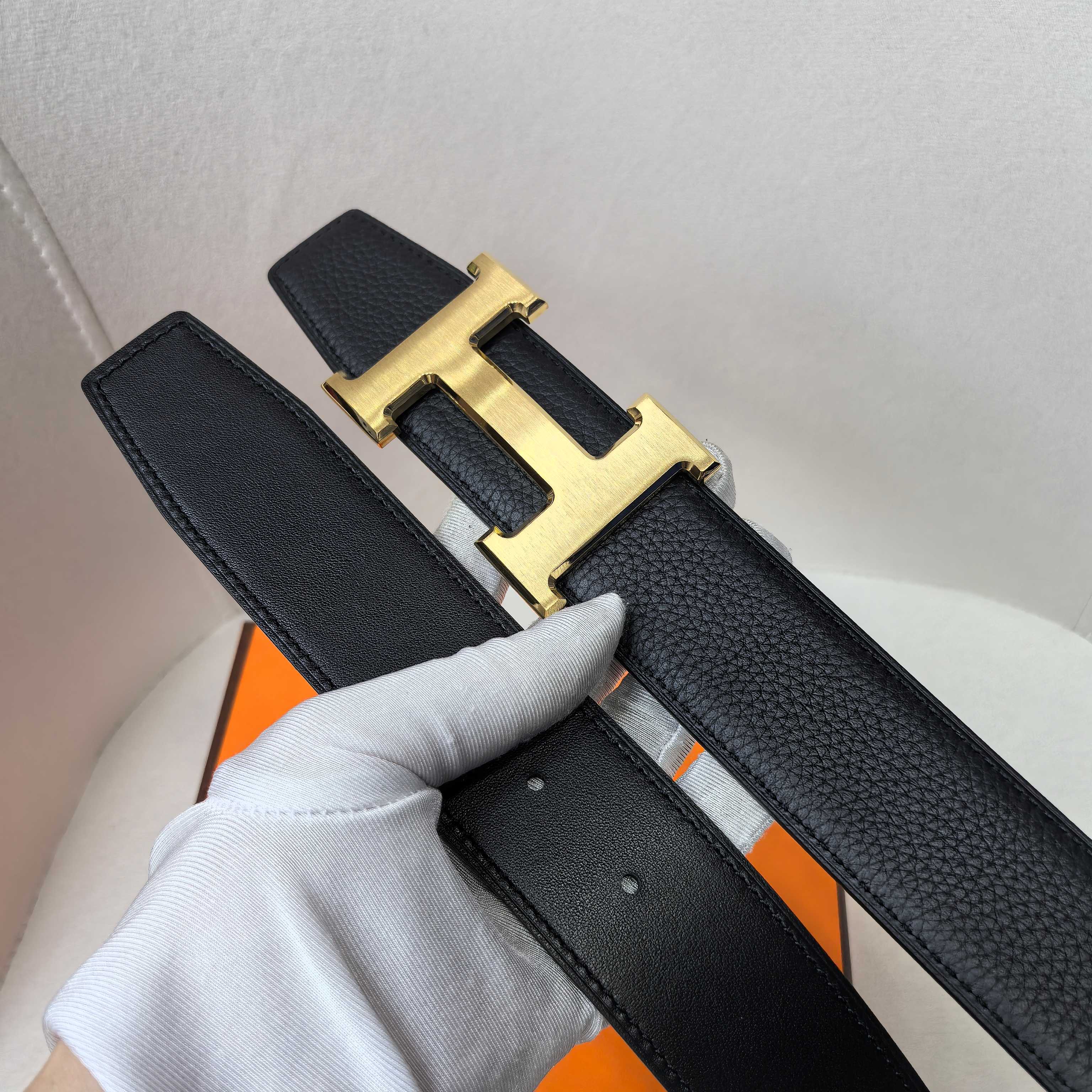 Hermes belt detail, black textured leather with gold-tone H buckle