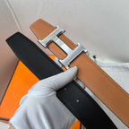 Hermes reversible belt showing black side and tan-brown front with silver-tone buckle