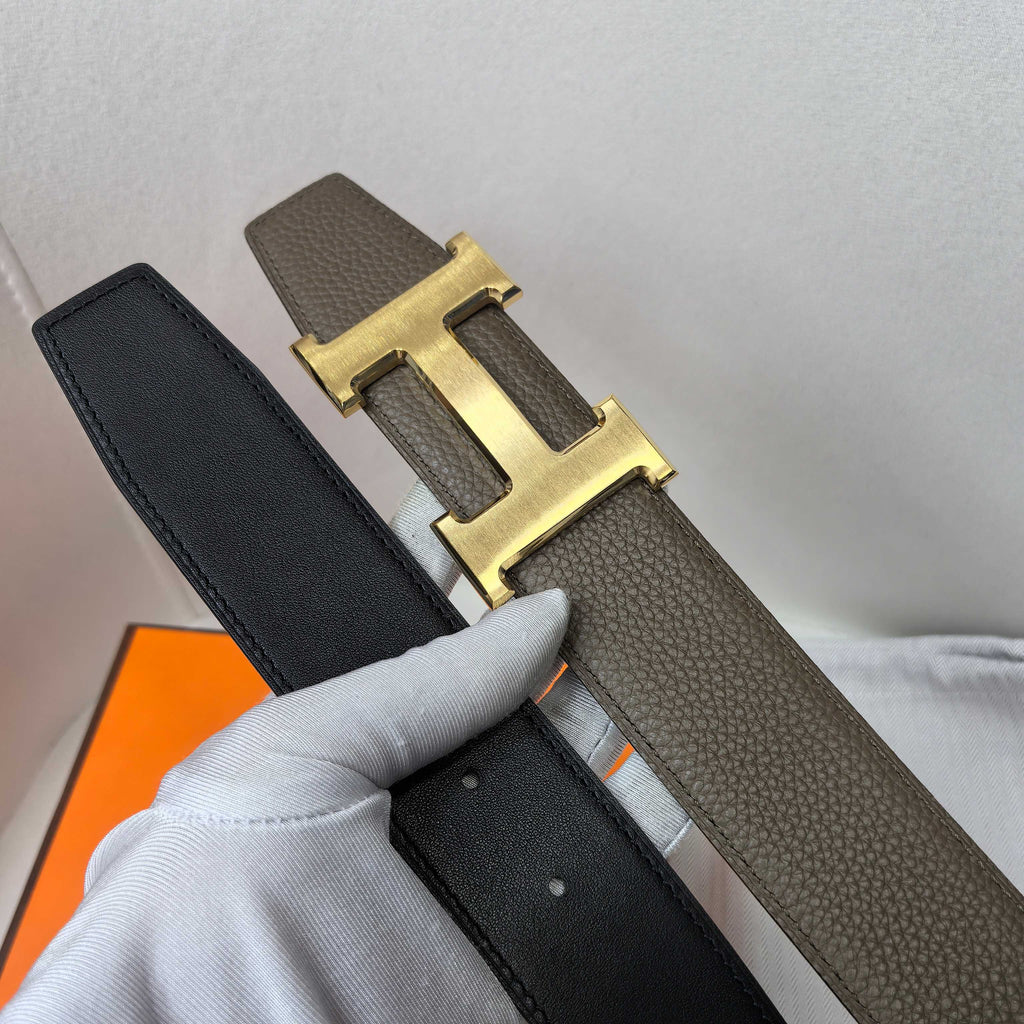 Hermes belt in dark leather with gold H buckle and strap edge detail