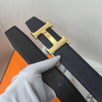 Hermes belt underside: dark leather strap with gold-tone H buckle and punched holes