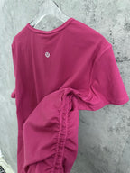 Pink ribbed short-sleeve top with back logo and draped front hem detail