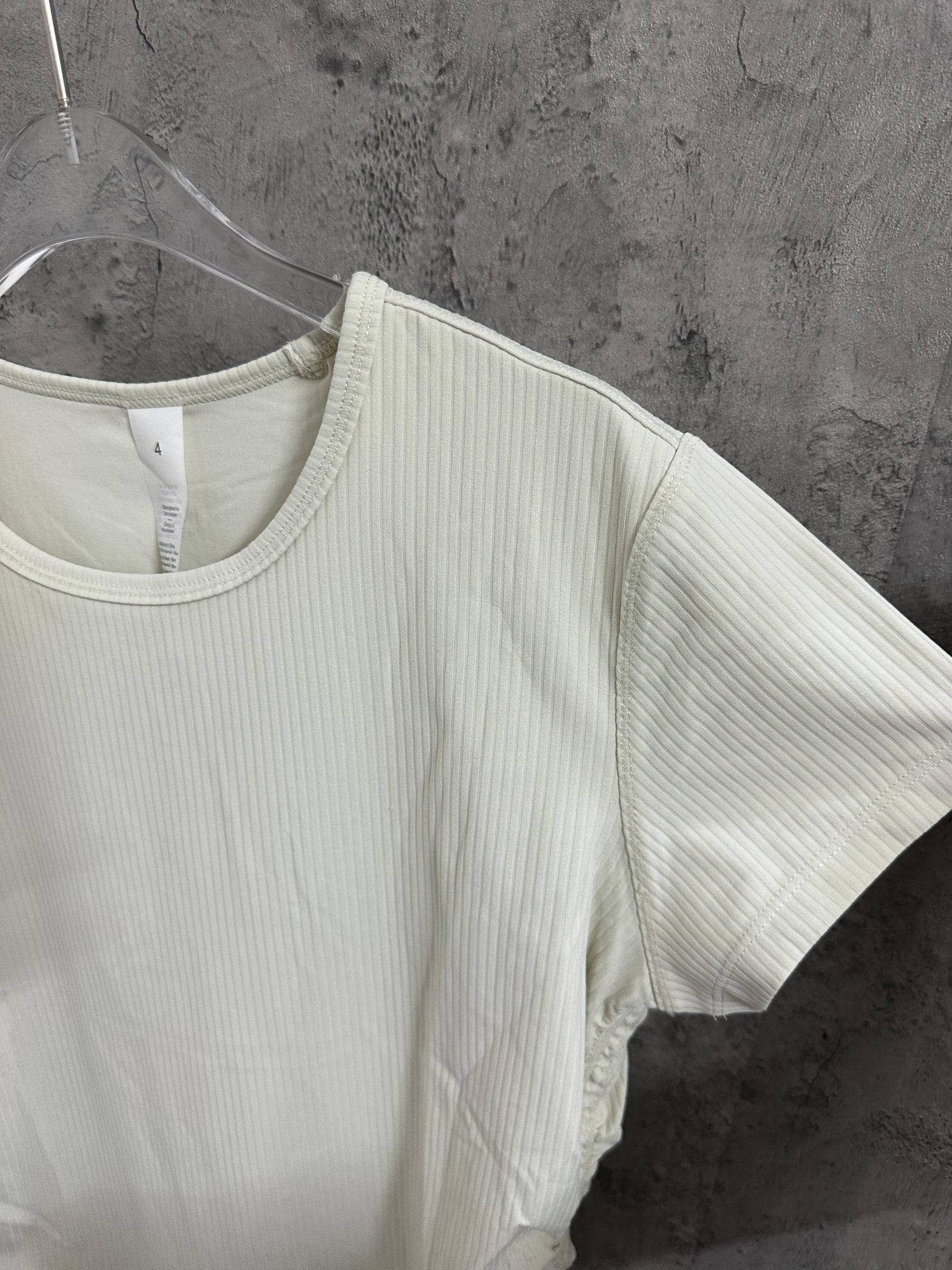 Off-white ribbed crew-neck T-shirt side view on hanger