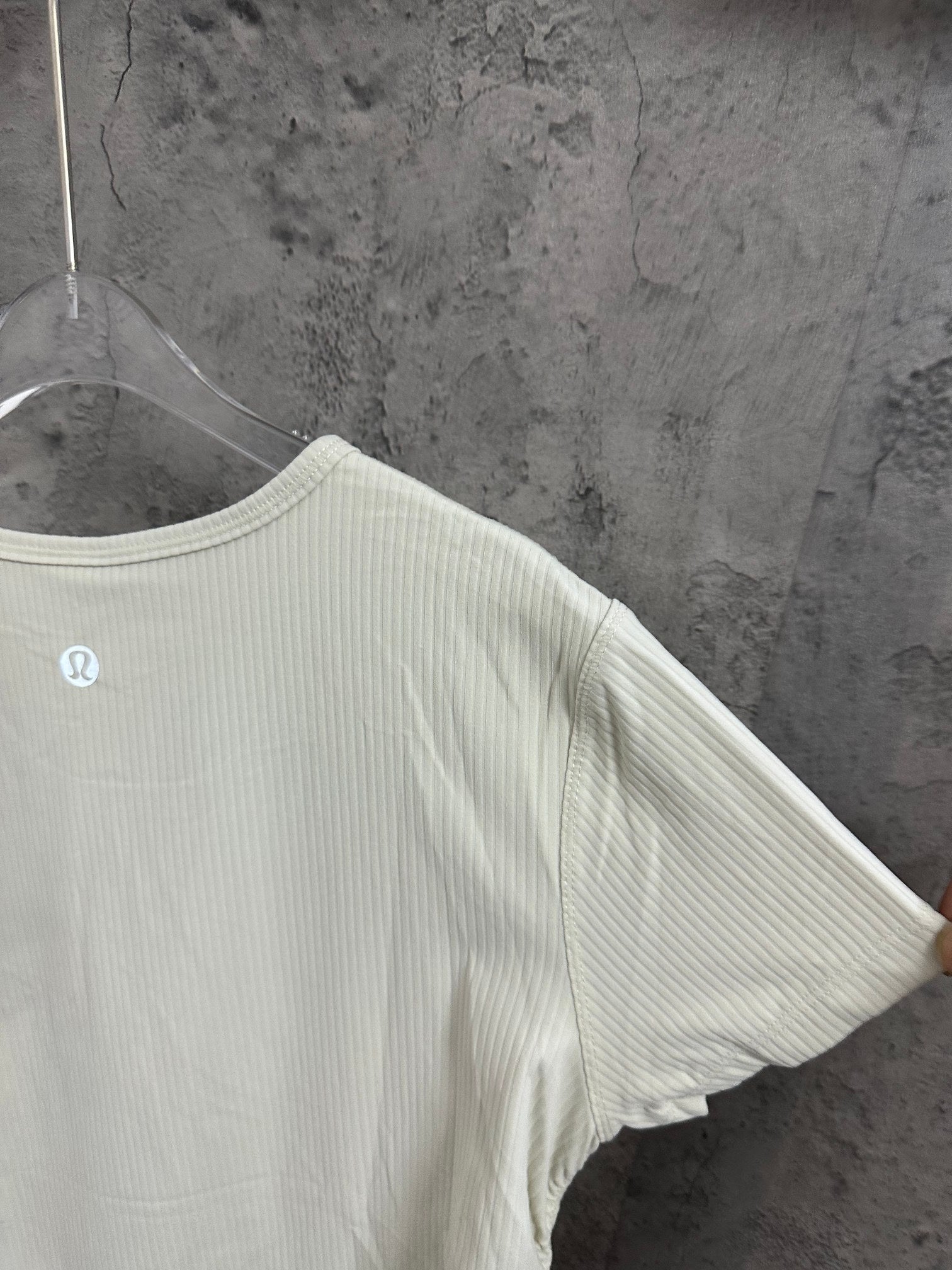 Off-white ribbed T-shirt sleeve and shoulder seam close-up