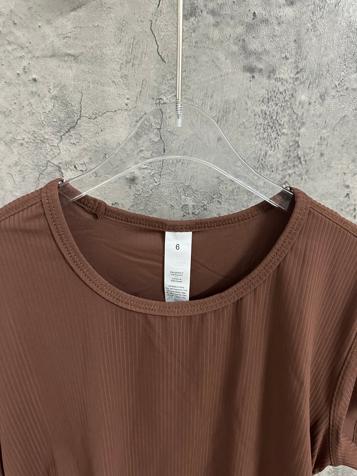 Brown ribbed crewneck T-shirt neckline with size label on hanger