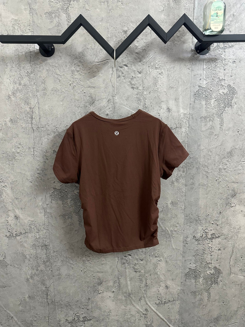 Brown short-sleeve crewneck T-shirt with ribbed texture on hanger