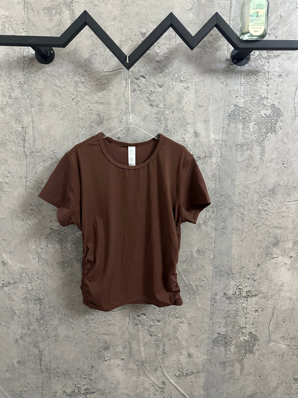 Brown short-sleeve ribbed crewneck T-shirt on clear hanger