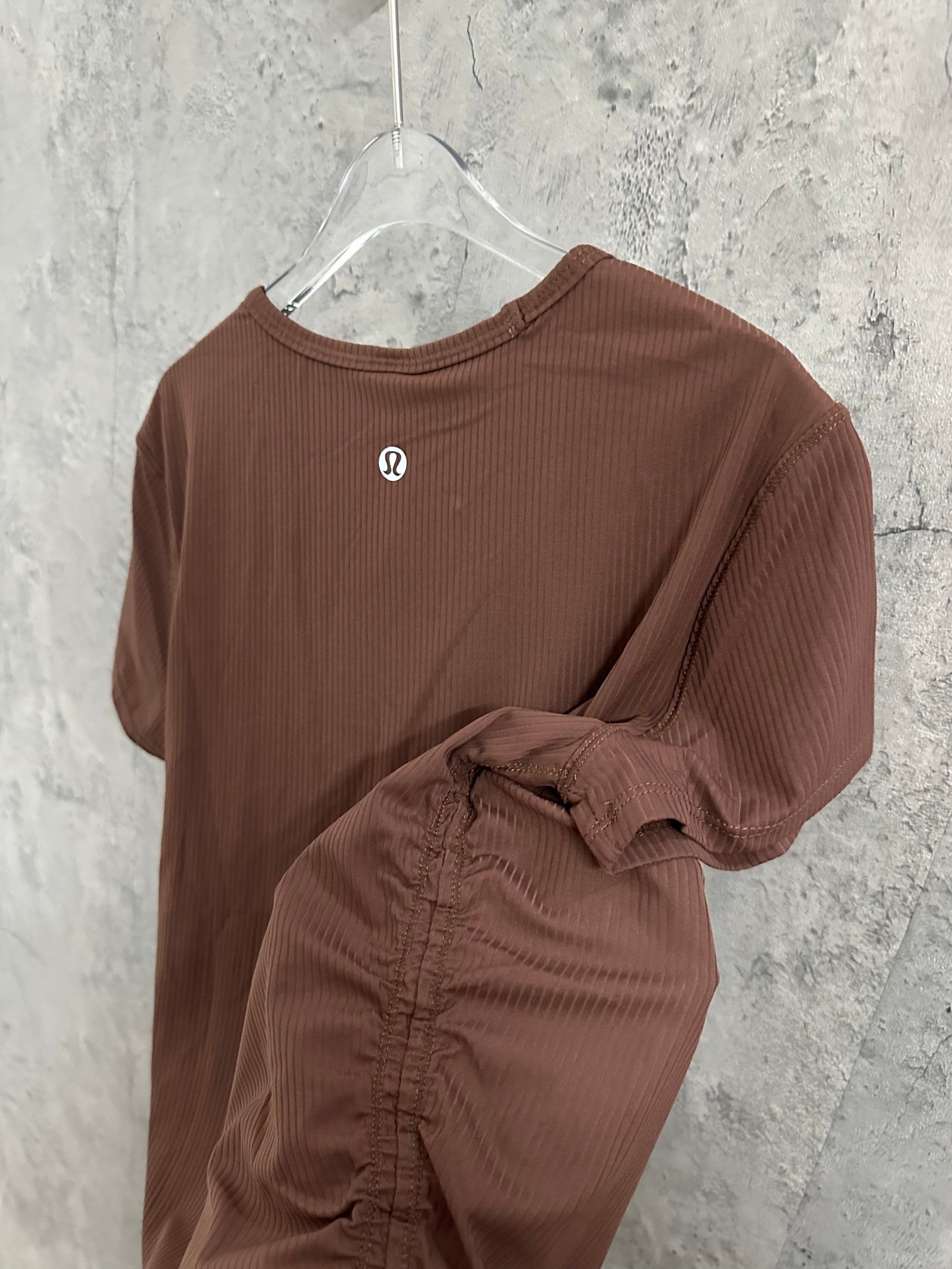 Brown ribbed short-sleeve T-shirt, front view with draped fabric