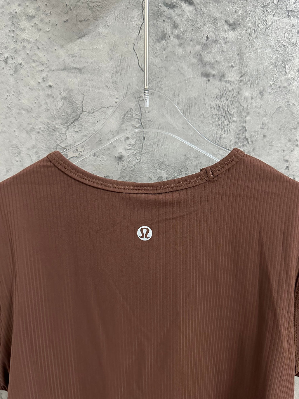 Brown ribbed crewneck T-shirt with small front logo on hanger