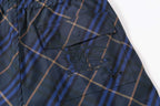 Navy plaid shorts with curved side pocket and stitched detail