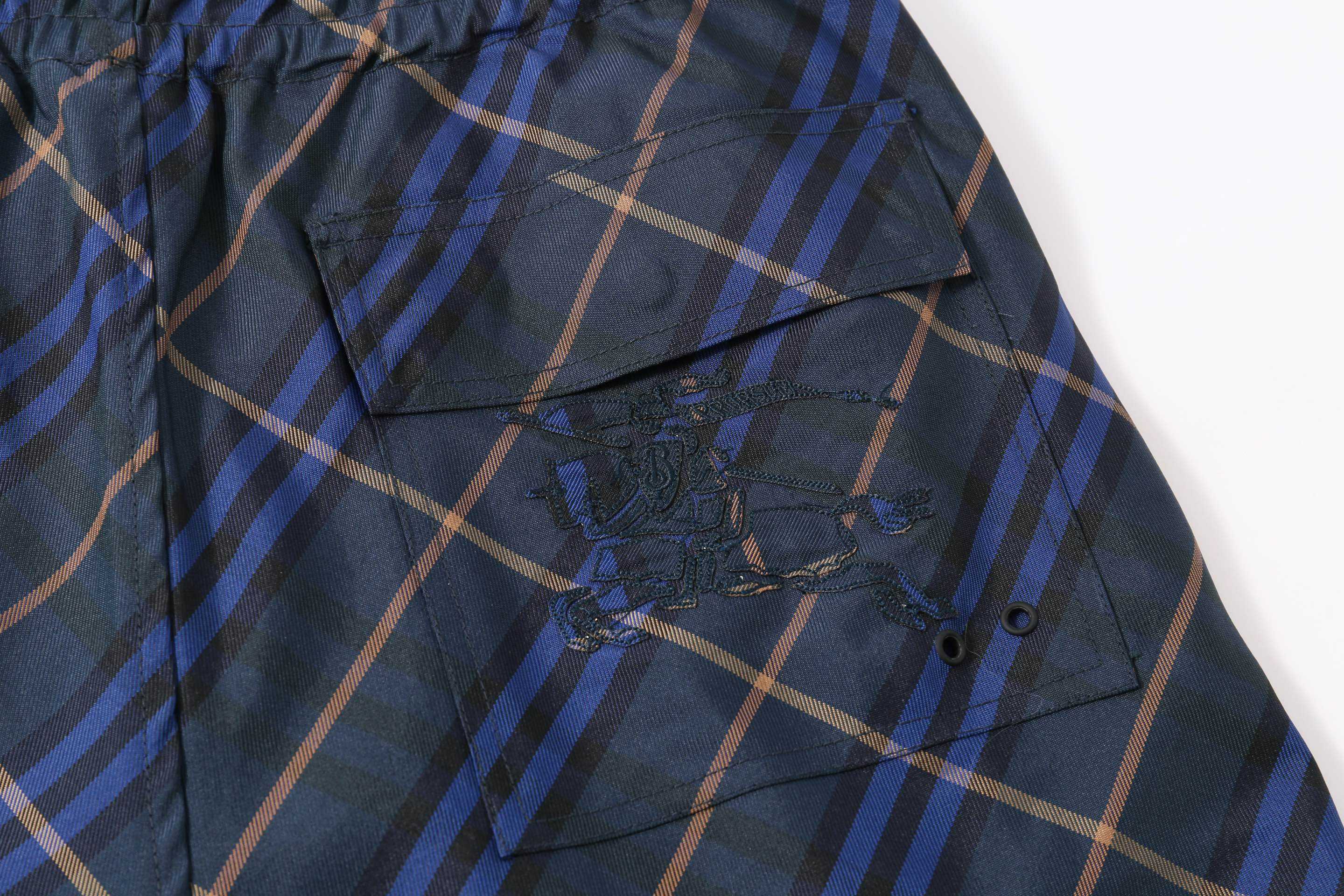 Navy plaid shorts with curved side pocket and stitched detail