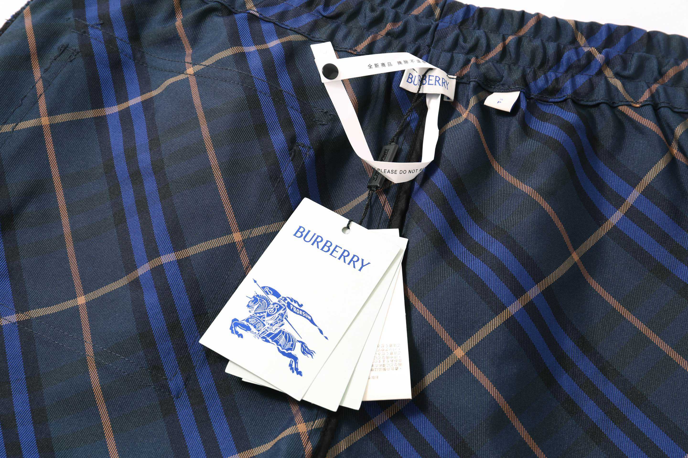 Burberry plaid shorts with swing tags attached to the waistband