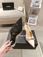 Women's pointed-toe slingback heels in black and beige with bow accents on box
