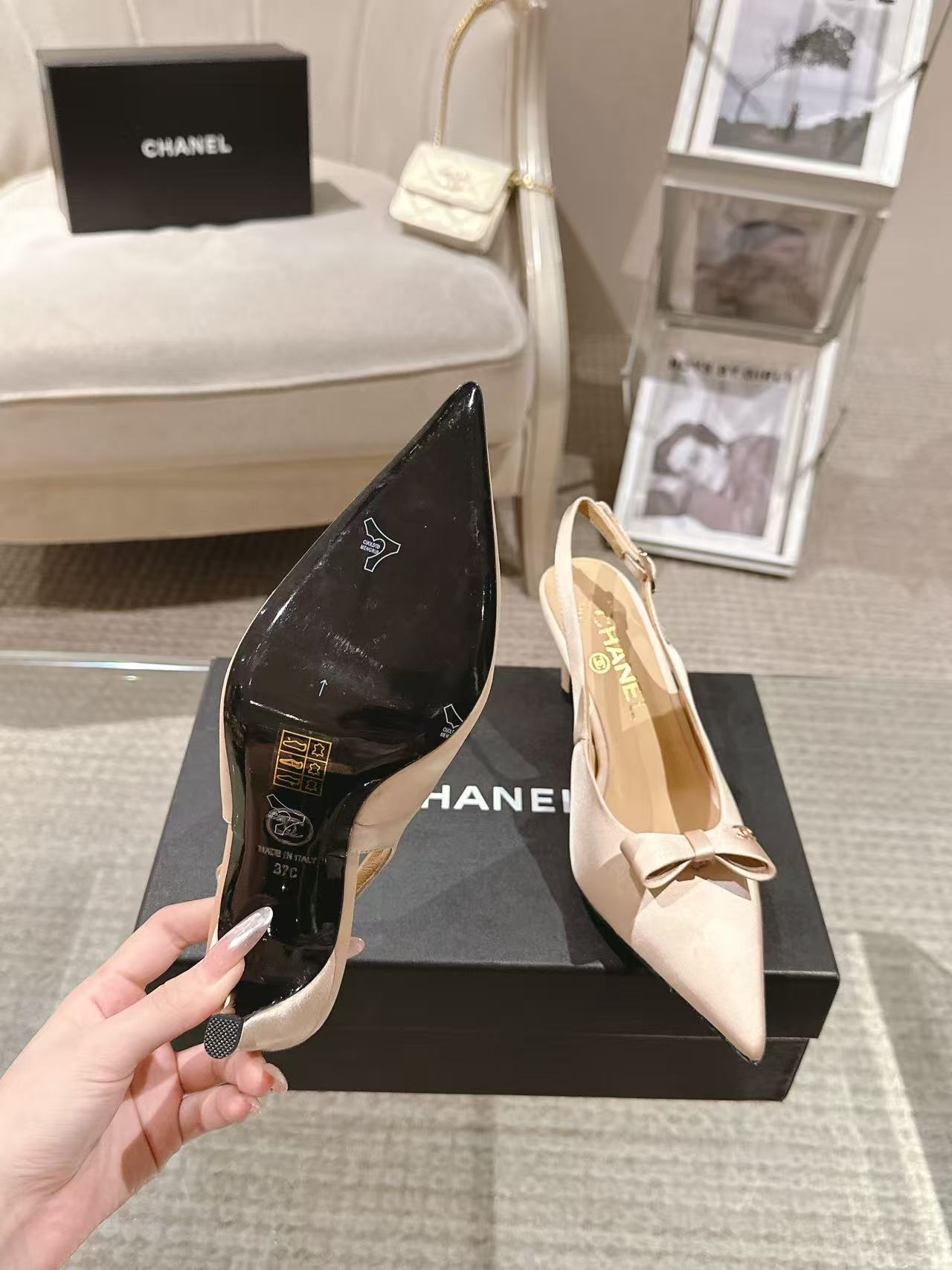 Women's pointed-toe slingback heels in black and beige with bow accents on box
