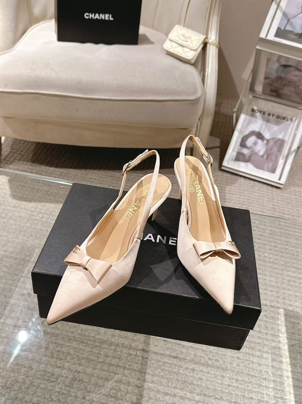 Women's beige pointed-toe slingback heels with bow and sling strap, shown on box