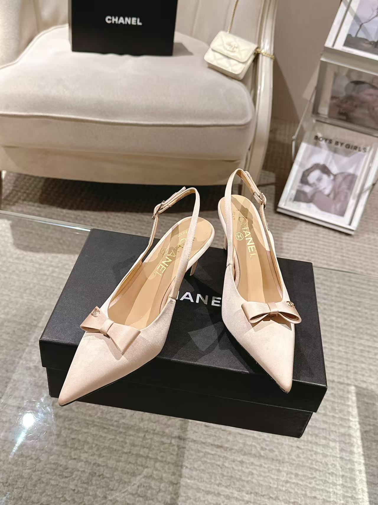 Women's beige pointed-toe slingback heels with bow and sling strap, shown on box