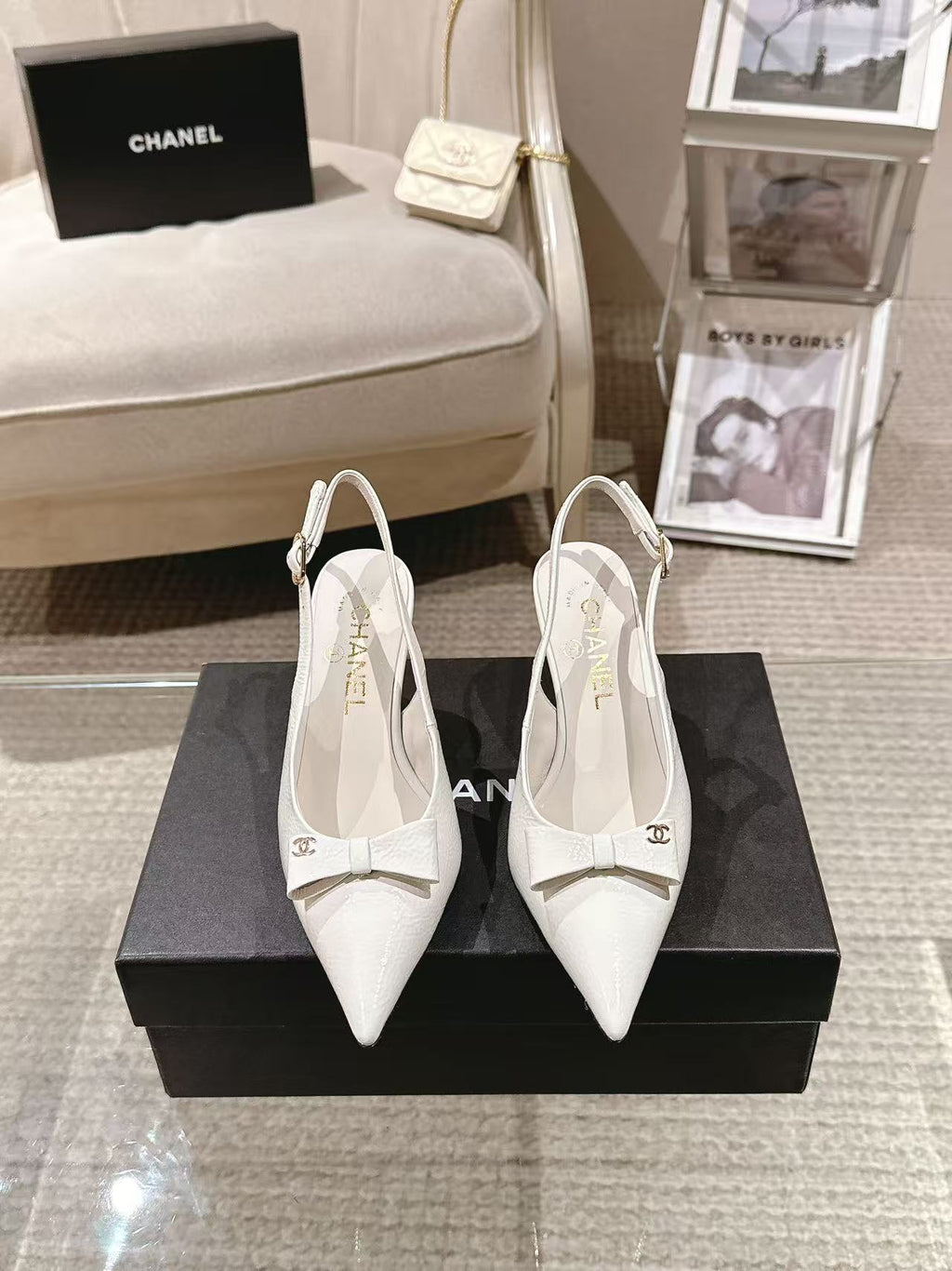 White pointed-toe slingback pumps with bow detail and slim black heel