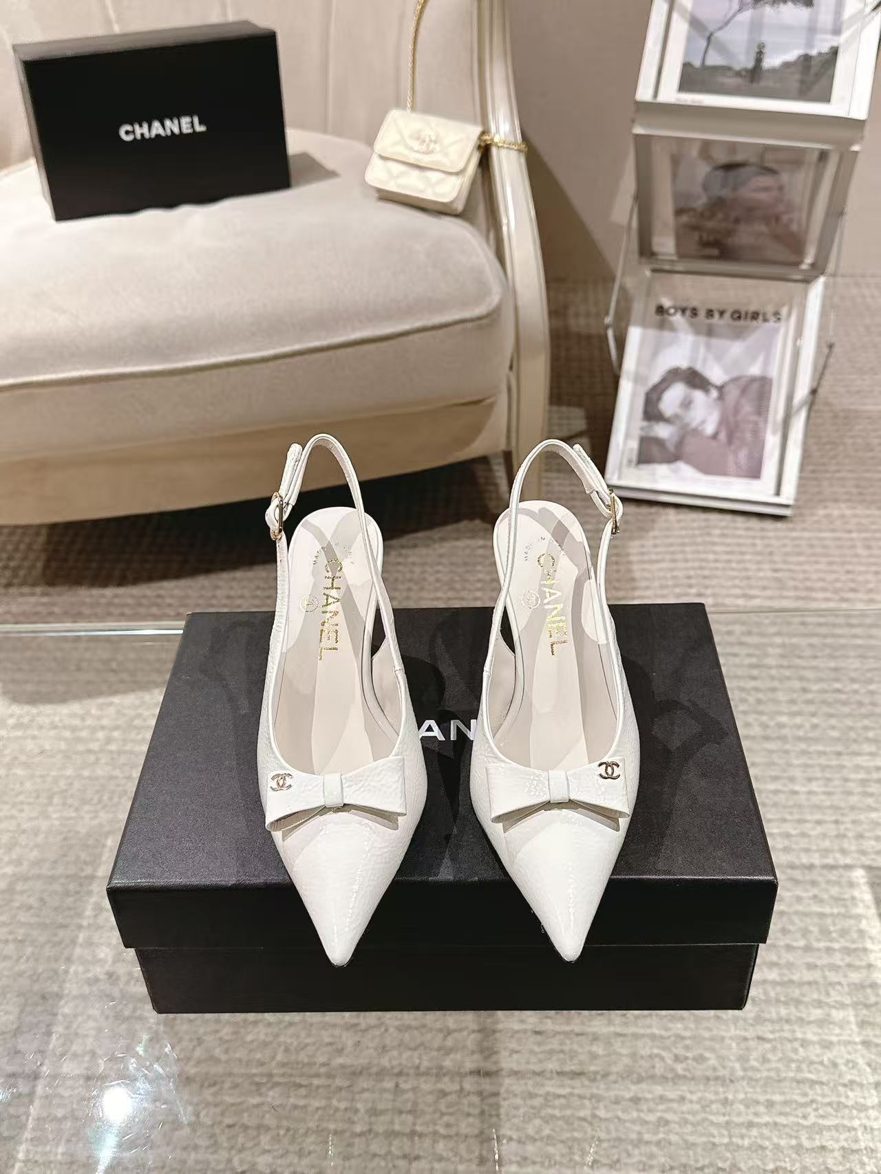 White pointed-toe slingback pumps with bow detail and slim black heel