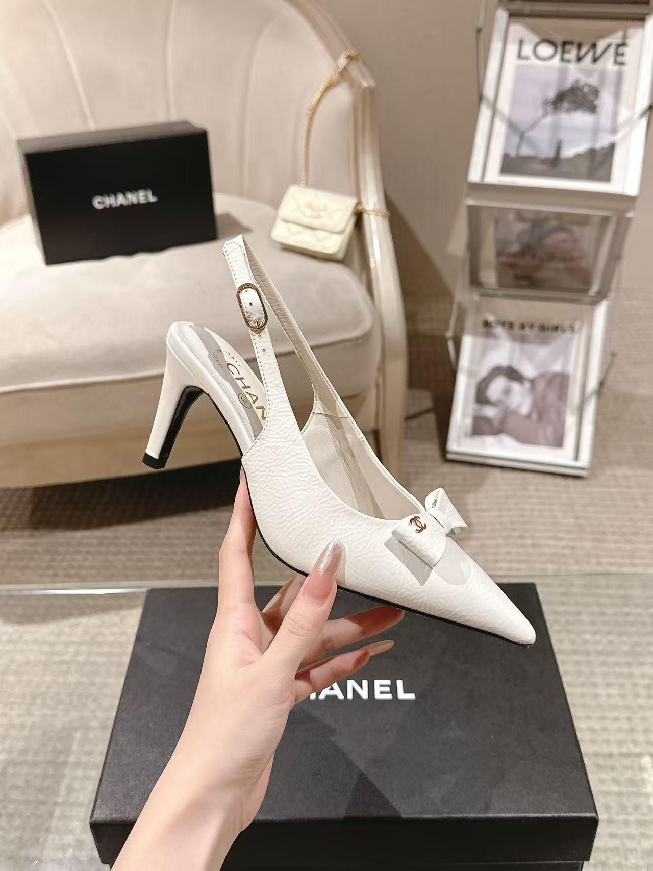 White pointed-toe slingback pumps with bow strap and slim black heel