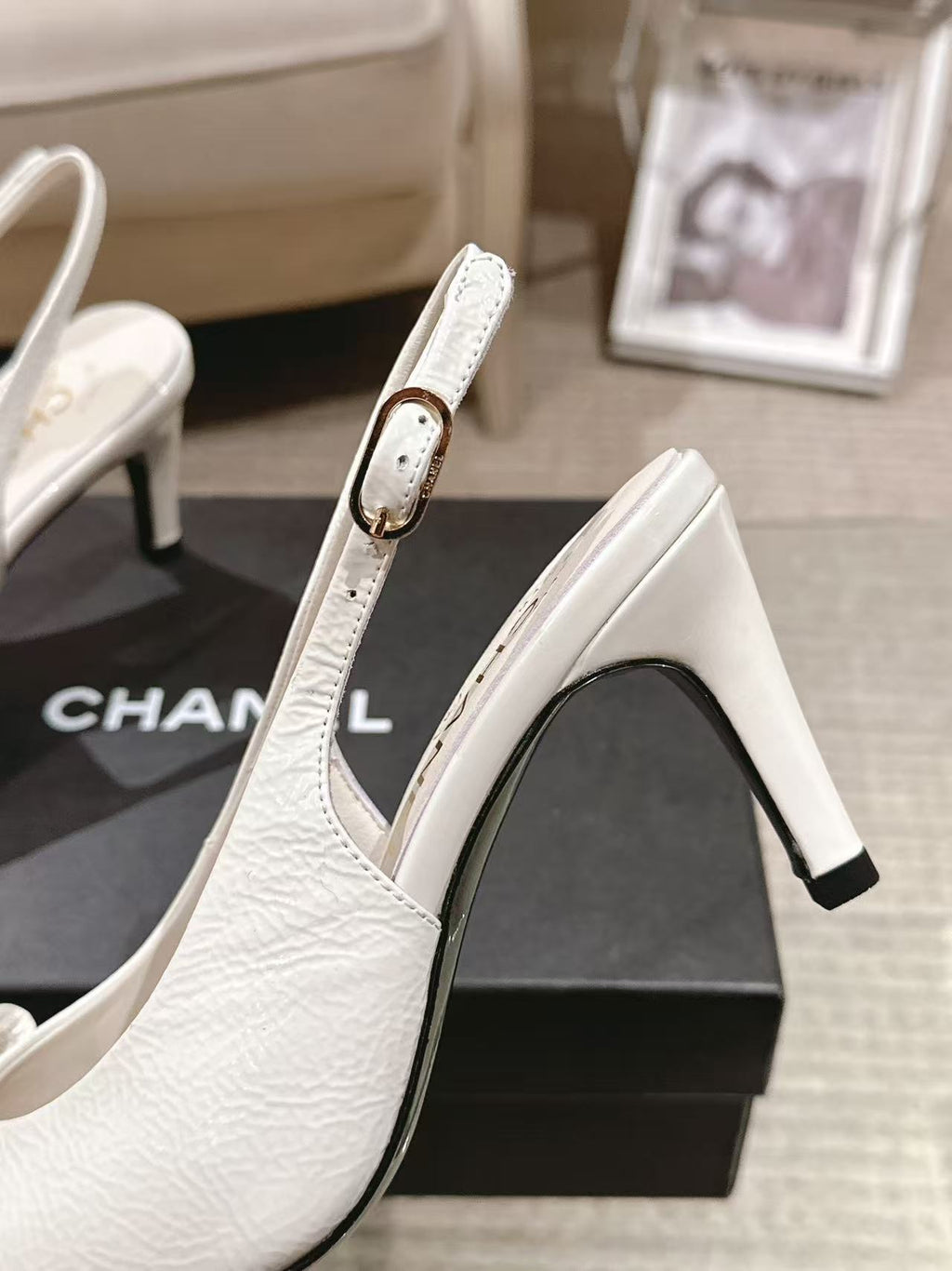 White leather slingback pump with slim black heel and pointed toe