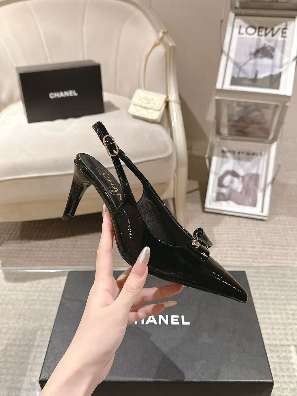 Chanel black patent slingback pump with pointed toe and mid-height heel, angled view
