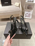 Chanel black patent slingback pumps with pointed toe and bow detail, heel view