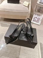 Chanel black patent pointed-toe pumps with slingback strap and bow detail