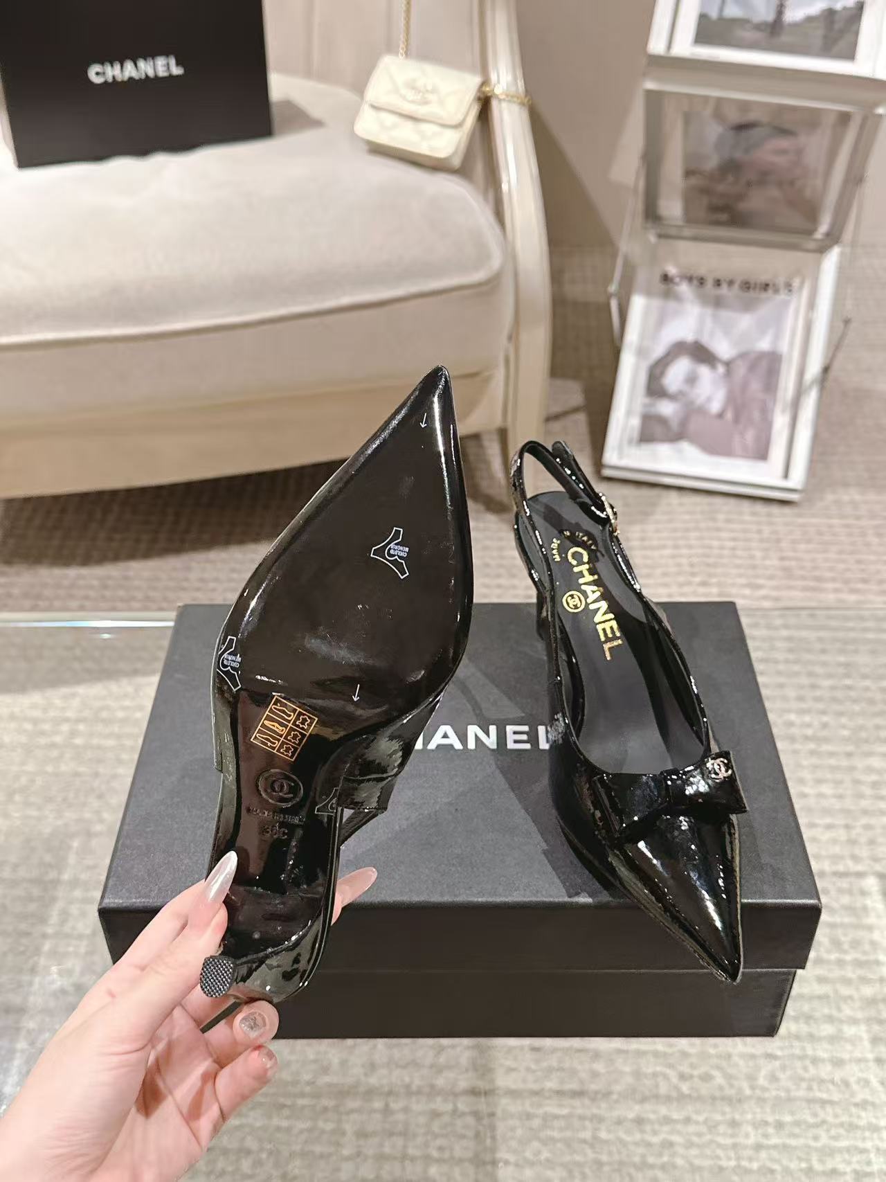 Chanel black patent slingback pumps with pointed toe and bow detail, front angle