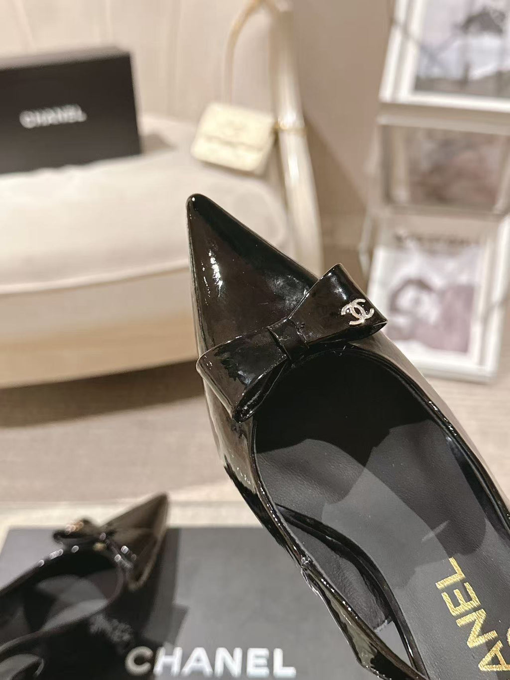 Chanel black patent pointed-toe slingback pump with small bow emblem, side view