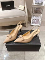 Women’s beige patent pumps with pointed toe, bow-tie slingback and slim stiletto heel