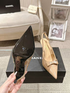 Women’s pointed-toe pumps in black patent leather with bow-tie slingback and slim heel