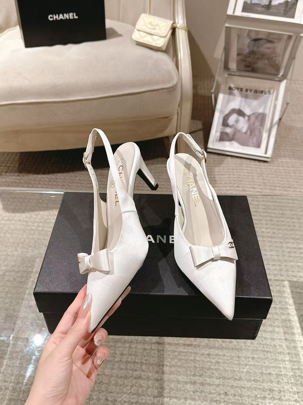 Chanel ladies white pointed-toe slingback pump held in hand