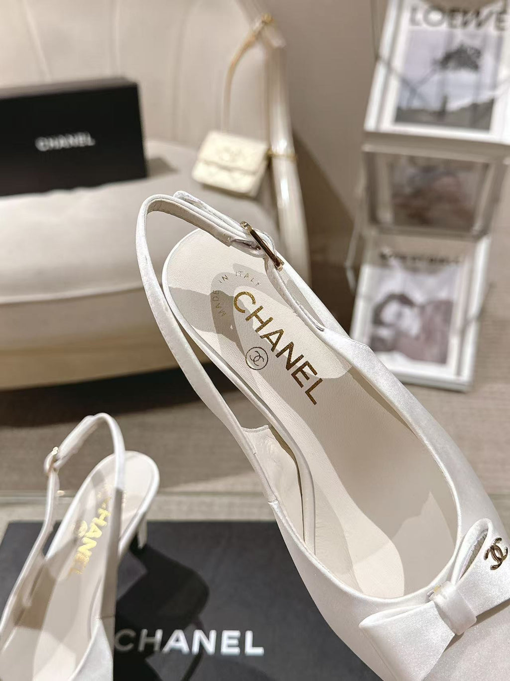 Chanel ladies white slingback pump with “CHANEL” logo on insole, angled view