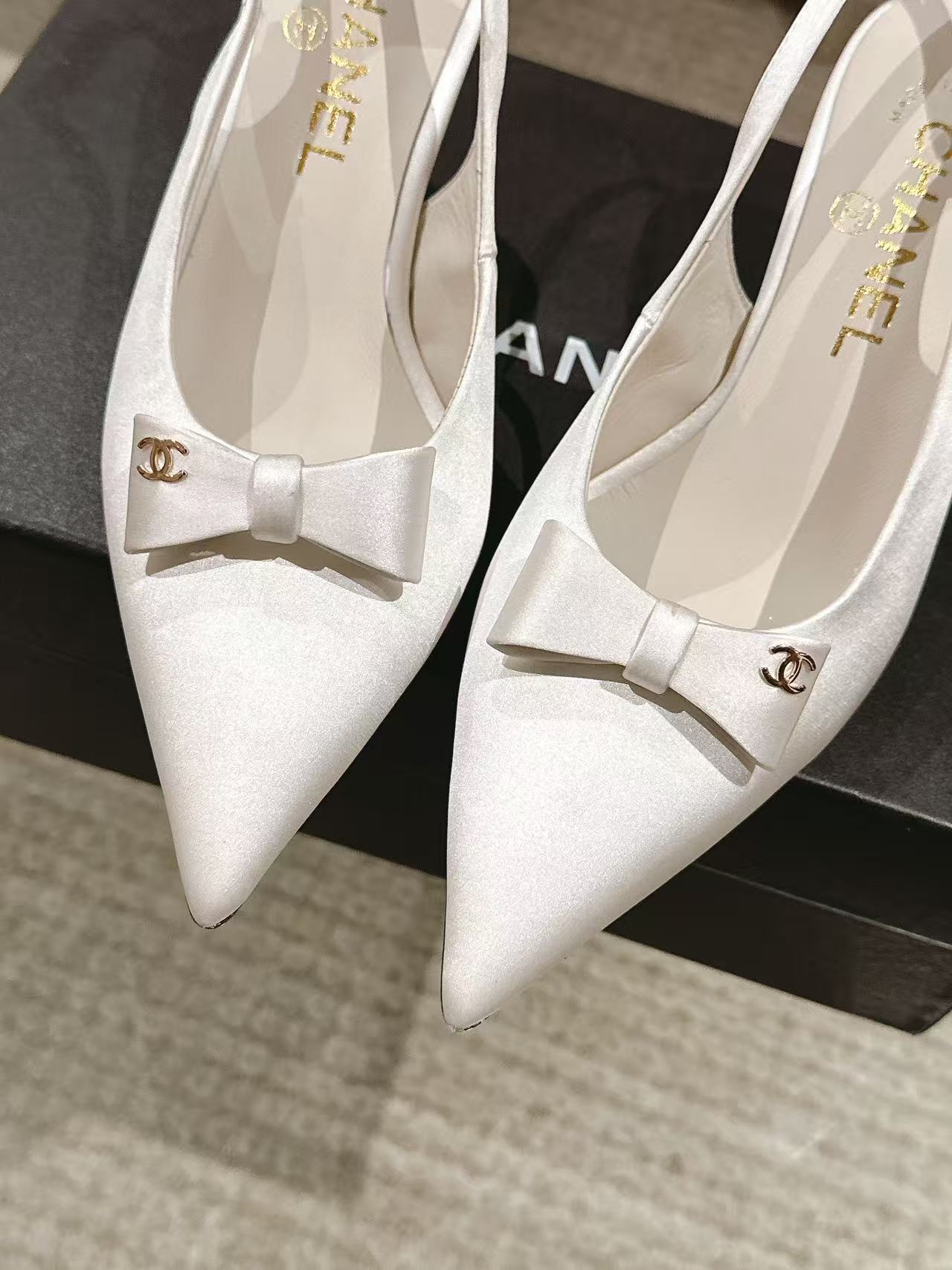 Chanel ladies white pointed-toe slingback pumps with bow, close-up pair