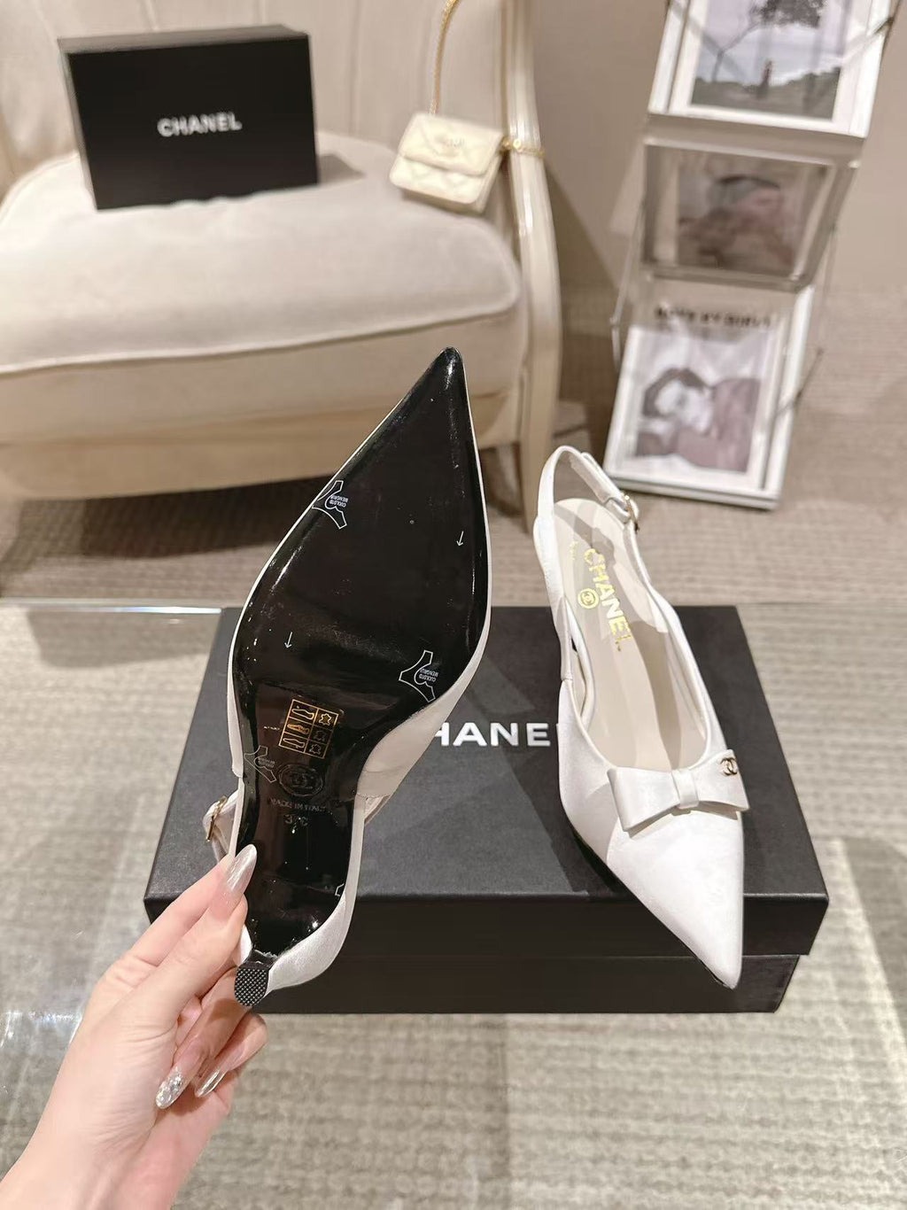 Chanel ladies black pointed-toe pump and white slingback pump on display boxes