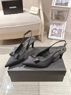 Black pointed-toe slingback pumps with bow and thin ankle strap