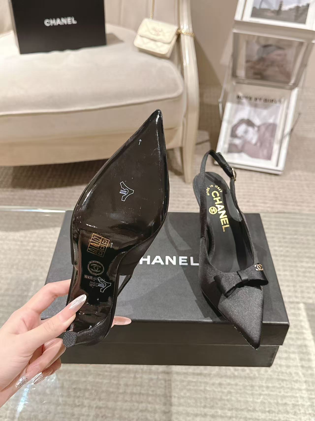 Black satin slingback pumps with pointed toe and bow at vamp