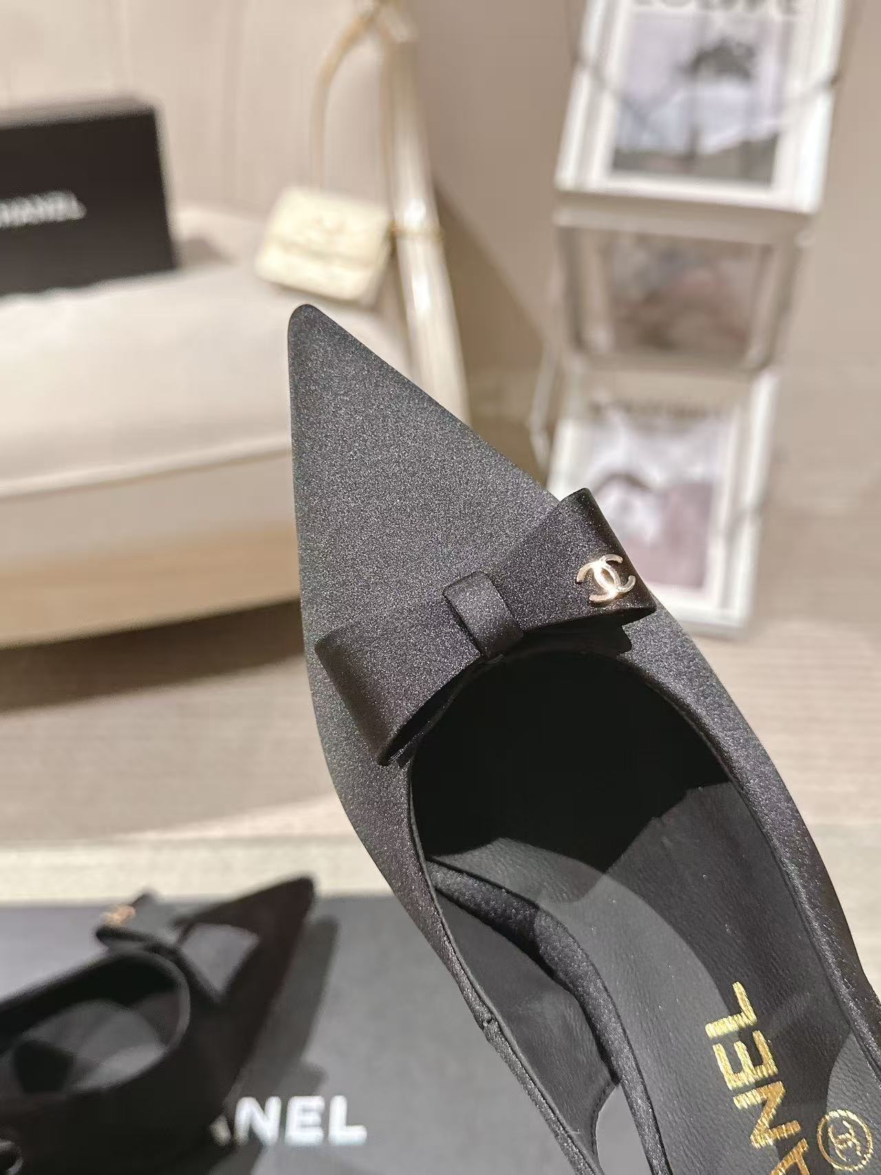 Black slingback pump side view with bow detail and CHANEL heel branding