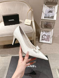 White pointed-toe slingback heel with slim buckle strap and bow detail