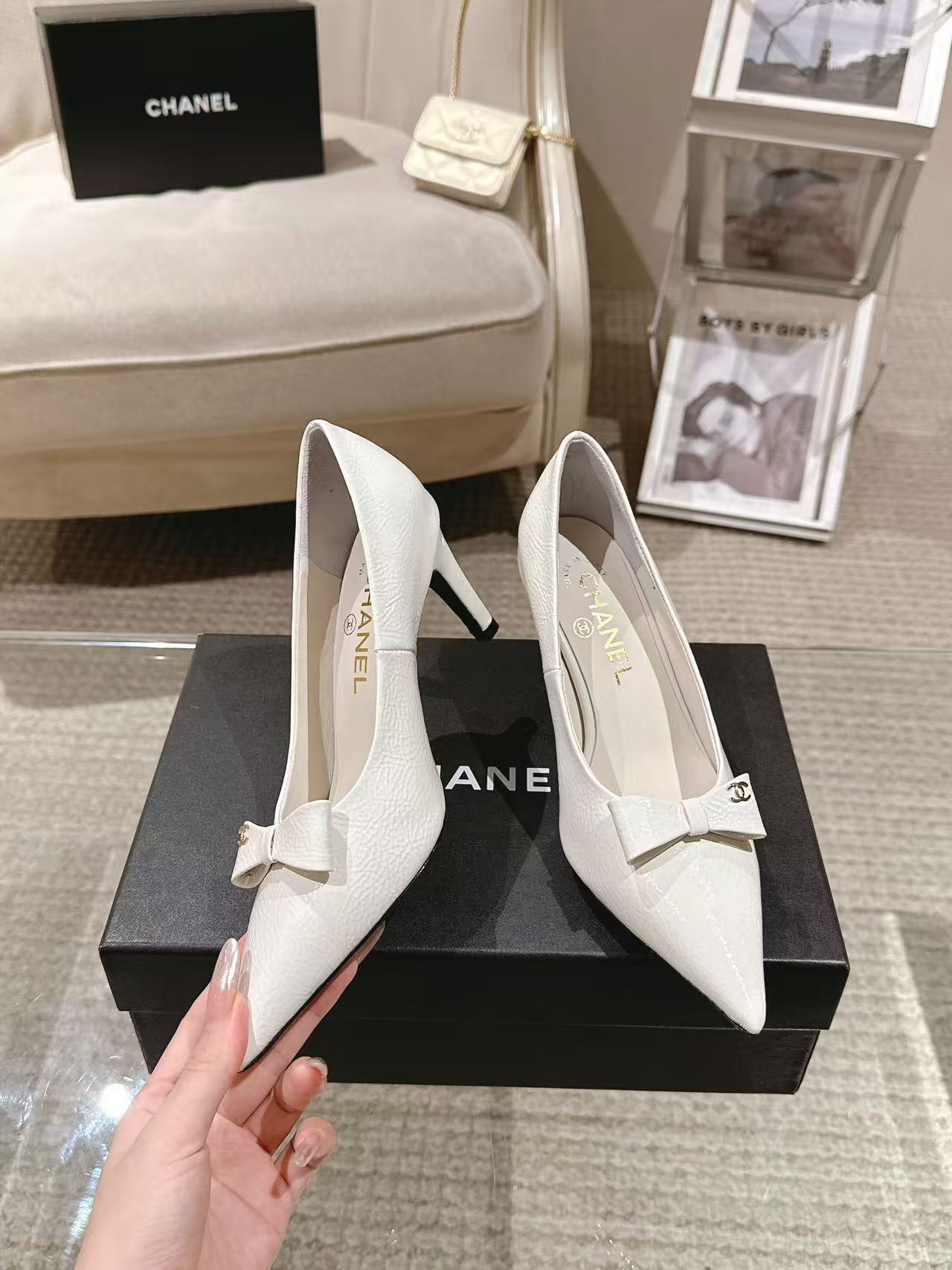 White pointed-toe slingback heels with bow strap, angled side view