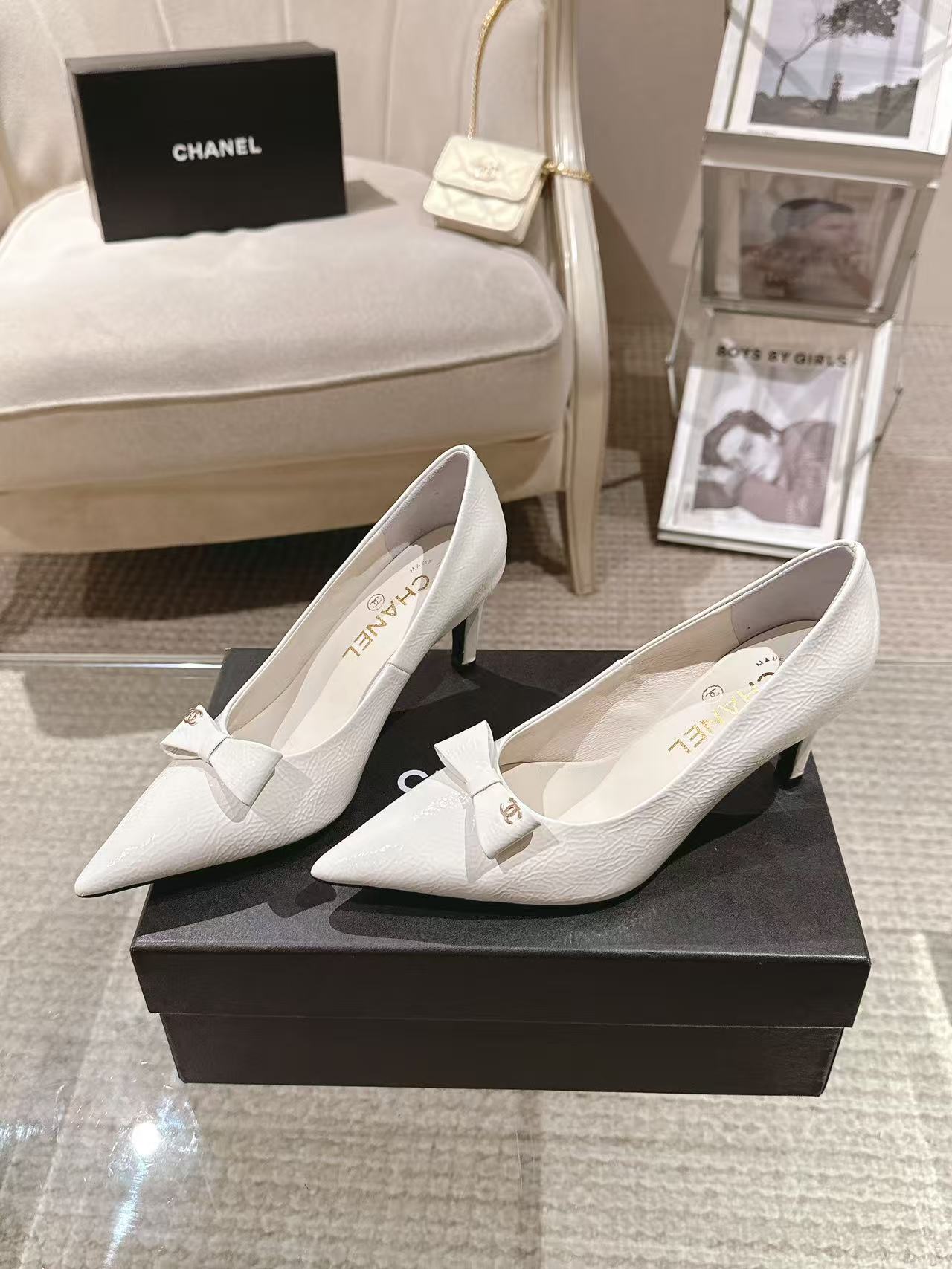 White pointed-toe slingback heels with bow strap, side view on display