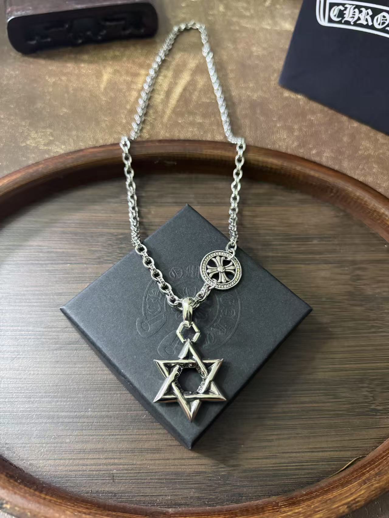 Silver-tone chain necklace featuring star of David and circular medallion