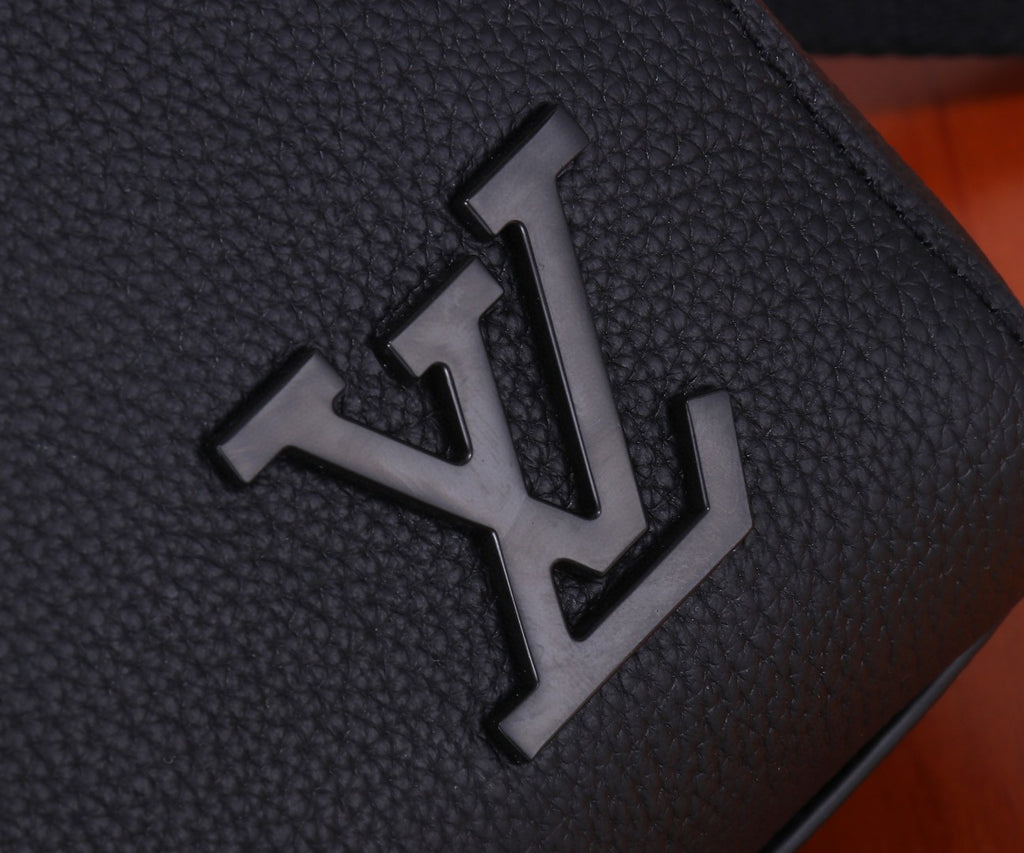 Louis Vuitton metal logo on textured leather flap, dark black.