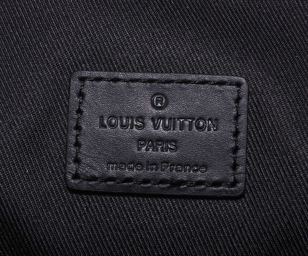 Louis Vuitton Paris leather label reading “made in France” on black fabric.
