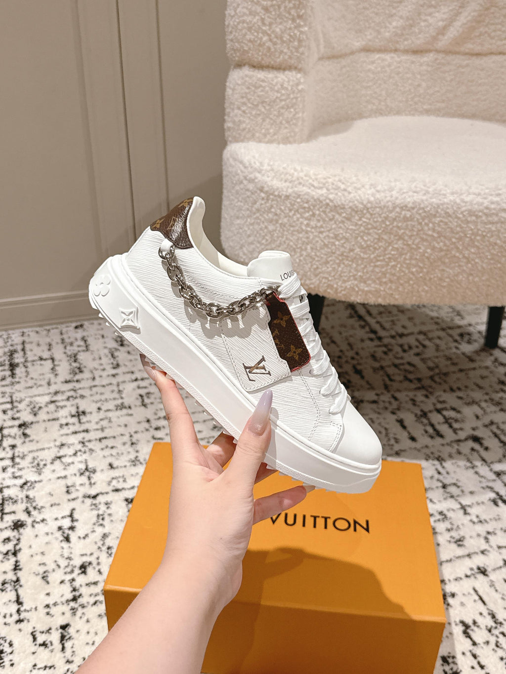 White Louis Vuitton sneaker with silver chain strap and embossed side logo