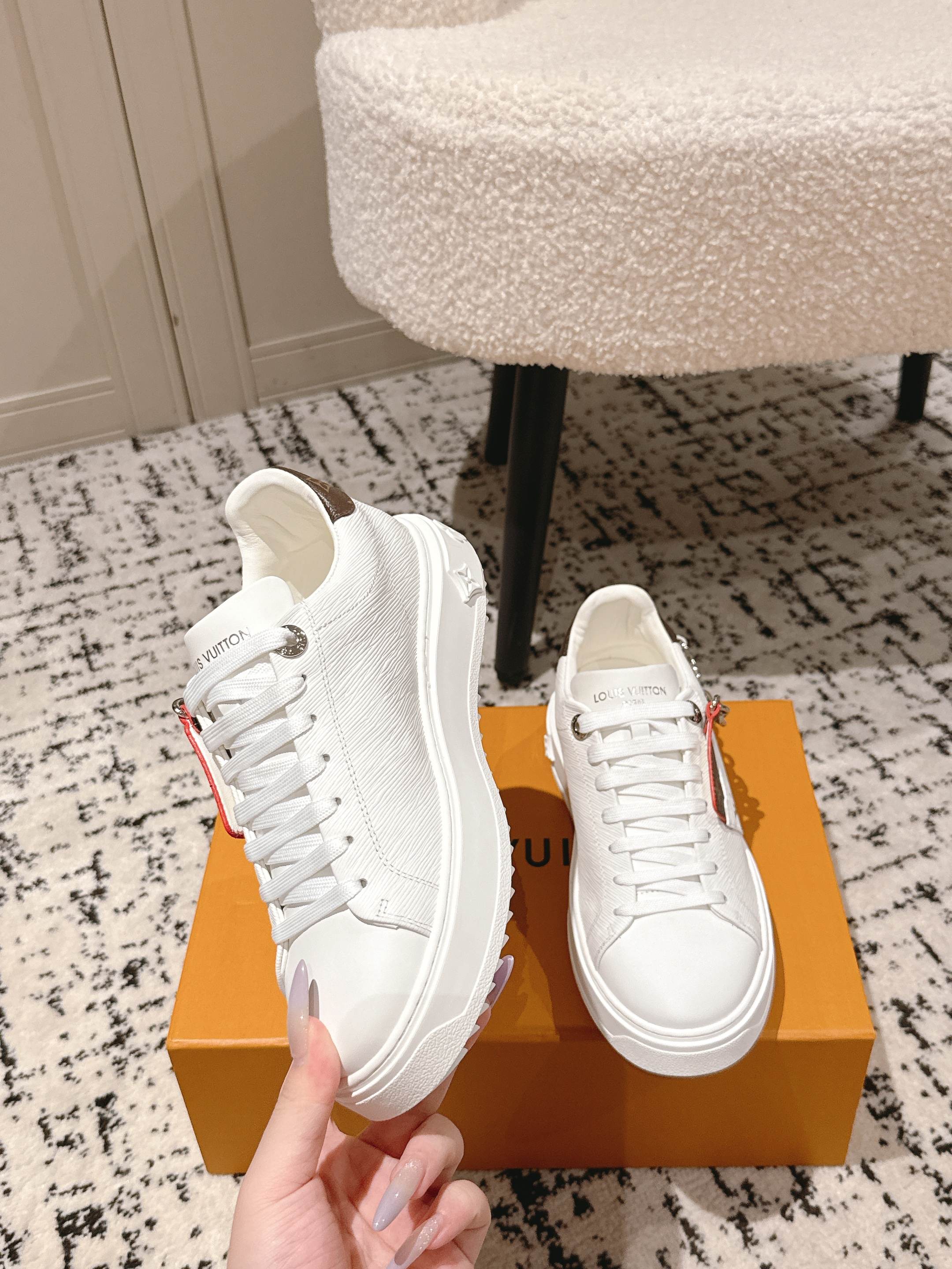 White Louis Vuitton low-top sneakers with chunky sole and silver chain strap